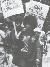 Picture of Angela Davis in a picket line holding a sign reading save the Soledad Brothers from Legal Lynching