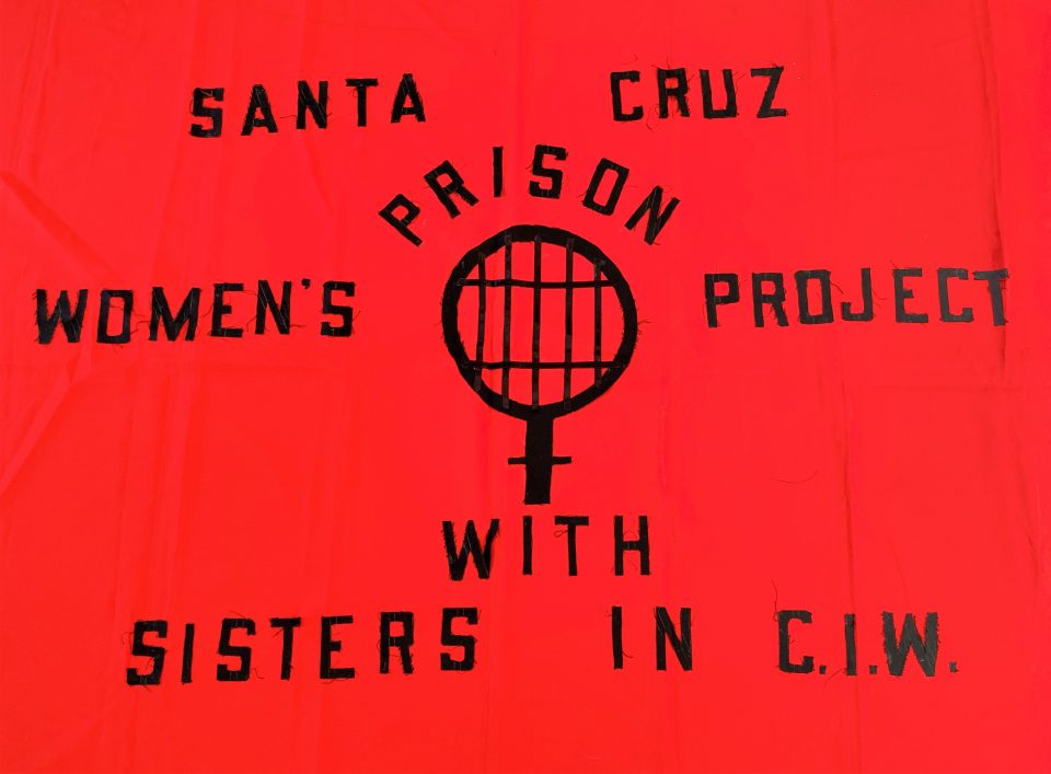 Red Banner with words Santa Cruz Womens Prison Project with Sisters in CIW